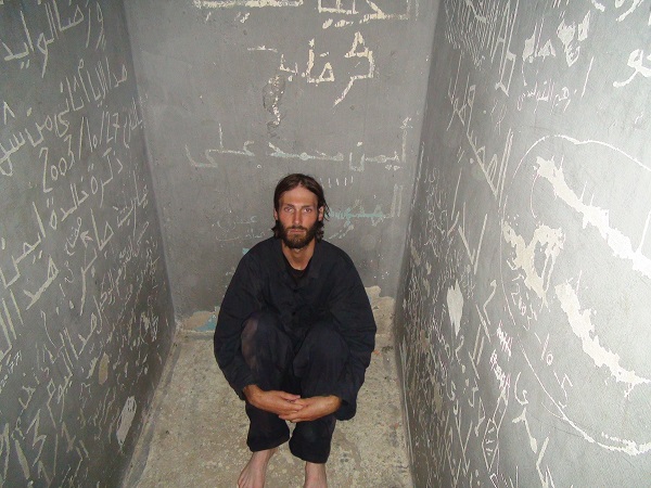 Matthew VanDyke sitting in the prison cell. Photo Credit: Nouri Fonas.