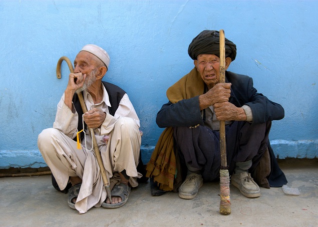 Two elderly men sit on the ground in Kabul. Photo Credit: Abdurahman Warsame/Flickr Creative Commons.