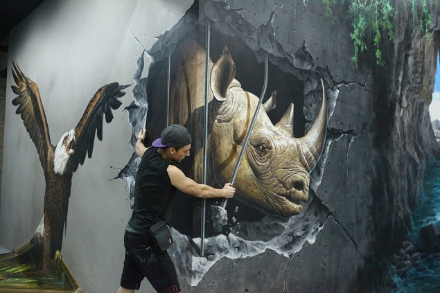 A visitor interacts with a painting at the Art in Island museum. Photo Credit: Art in Island.