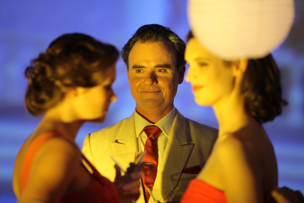 Orry-Kelly played by Darren Gilshenan with cocktail party guests. Photo: Hollywood Classics.